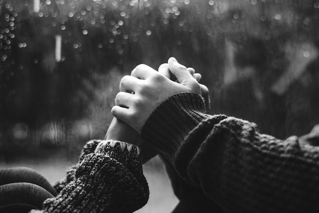 Happy couple holding hands by the window